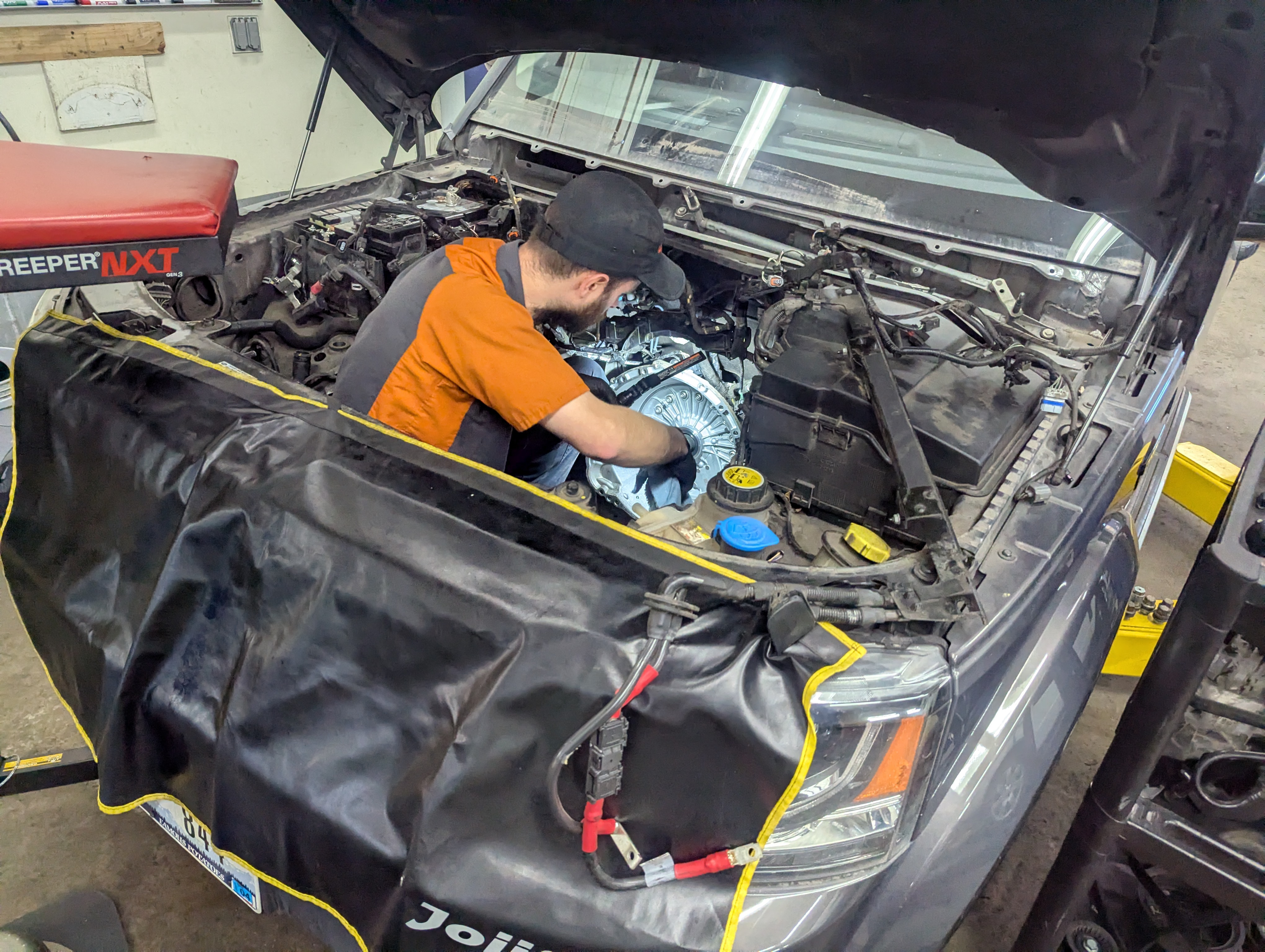 Technician working on Land Rover LR4 engine replacement at Lux AutoHause